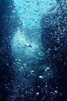 the water is very blue and it looks like bubbles are coming out of the ocean