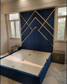 a bed that is in the middle of a room with blue headboard and foot board