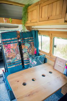 the inside of a camper with wooden tables and chairs