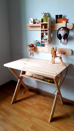 a wooden desk sitting on top of a hard wood floor next to a white wall