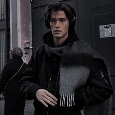 a man with headphones on walking down the street