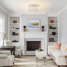 a living room filled with furniture and a fire place in front of a white fireplace