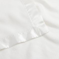 an unmade bed with white sheets and pillow cases on it's side, close up