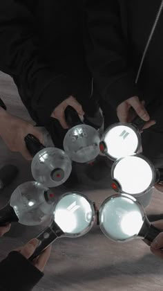 a group of people holding magnifying glasses in the shape of five circles with their hands