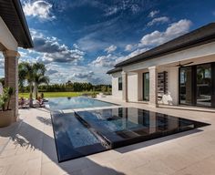 an outdoor swimming pool in front of a house