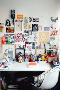 a white desk topped with lots of pictures