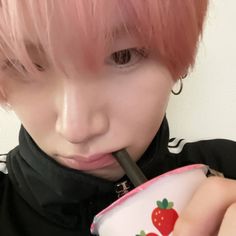 a person with pink hair drinking from a straw