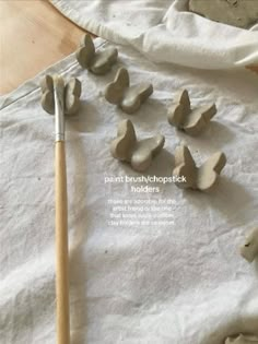 the paint brush is laying next to several pieces of clay that are shaped like birds