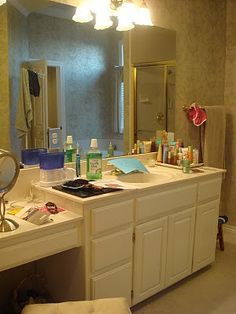 a bathroom with a sink, mirror and toiletries on the counter in front of it