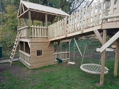 a wooden play house with a swing set