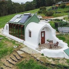 a small white house with a green roof