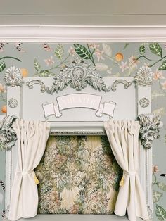 an ornate wallpapered room with curtains and flowers on the window sill,