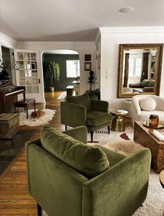 a living room filled with lots of furniture and a large mirror on the wall above it