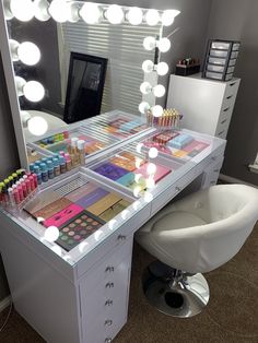 a vanity with makeup and lights on it