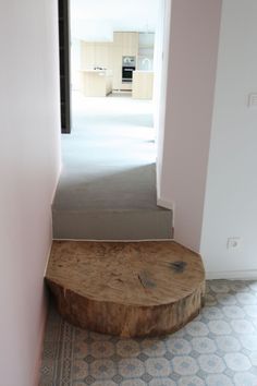 a wooden bench sitting in the middle of a room next to a doorway with an open door