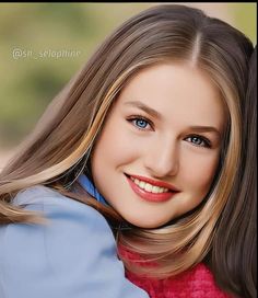 a woman with long blonde hair and blue eyes smiles at the camera while wearing a red sweater