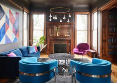 a living room filled with blue couches and chairs in front of a fire place