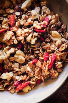 a bowl filled with granola and nuts on top of a table