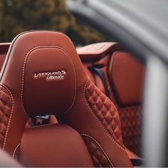 the interior of a sports car with red leather upholstered and stitched seats