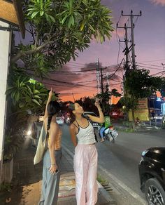 two women standing on the side of a road