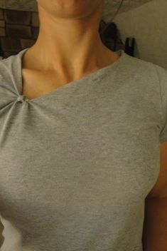 a woman wearing a gray shirt with a bow on the front and back of her neck