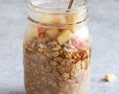 a jar filled with granola sitting on top of a table next to a spoon