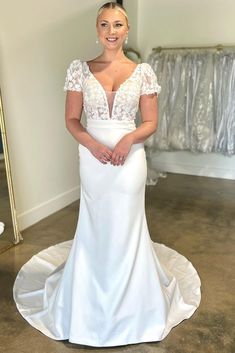 a woman in a white wedding dress posing for the camera with her hands on her hips