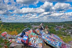 people are sitting on top of graffiti covered rocks