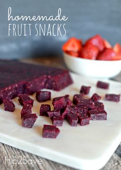 homemade fruit snacks on a cutting board with strawberries