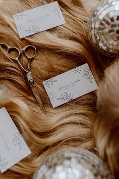 some scissors are laying on top of some hair with tags in front of the scissors