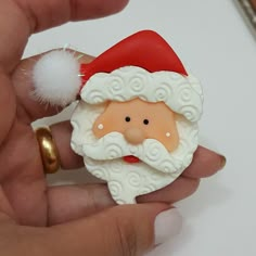 a hand holding a small santa clause ornament