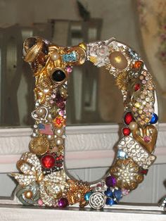 a close up of a mirror with jewelry on the frame and in front of it