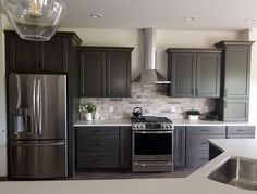 a kitchen with gray cabinets and stainless steel appliances