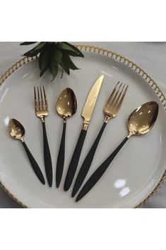 a white plate topped with black and gold utensils