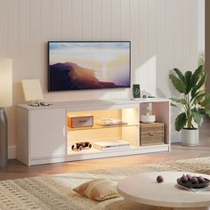 a living room with a large flat screen tv on top of a white entertainment center