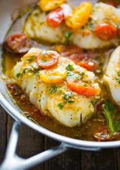 some kind of food that is in a pan on a wooden table and ready to be eaten