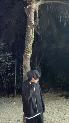 a man standing next to a palm tree