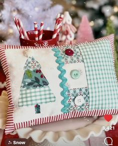 a decorative pillow with christmas trees on it and candy canes in the back ground