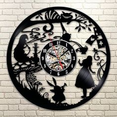 a black clock with alice and the neverlander silhouettes on it's face