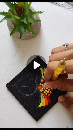 a woman is drawing on a piece of paper with her fingers and fingernails