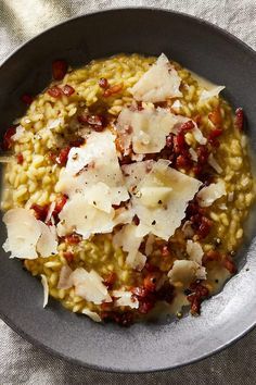 a bowl filled with riso and cheese on top of a white cloth covered table