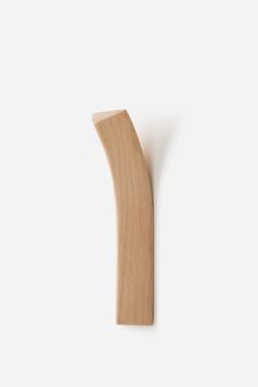 a wooden toothbrush against a white wall with the top half cut out to show it's teeth