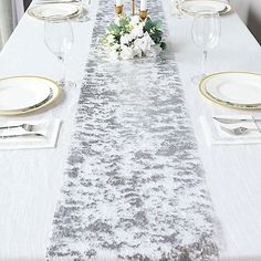 the table is set with white and gold place settings