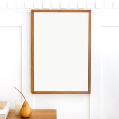 a pear sitting on top of a wooden table next to a white board and books