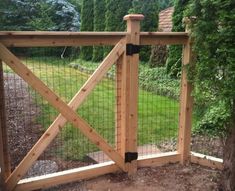 a gate that has been built into the side of a house with a tree in it