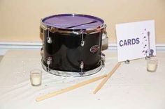 there is a black drum set on the table with candles and cards next to it