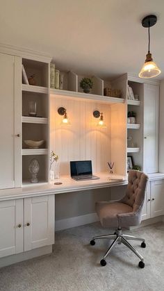 a home office with built - in shelving, desk and chair