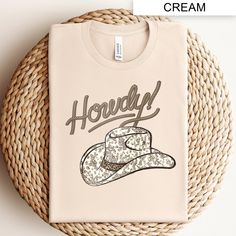 Embrace the western spirit with our Howdy T-Shirt, featuring a stylish cowboy hat graphic. This country themed western shirt is perfect for those who love classic country fashion. Whether you're heading to a rodeo or just want to show off your country pride, this vintage style tee is a must-have addition to your wardrobe. Comfortable, versatile, and timeless, it's ideal for any casual occasion or country music event. Cowboy Hat Graphic, Mode Country, Vintage Western Shirt, Graphic Tee Vintage, Western Apparel, Chapeau Cowboy, Country Fashion, Cow Boy, Music Event