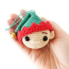 a small crocheted doll with a hat on it's head is held in someones hand