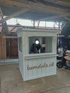 a man standing behind a small building with the word lavendalia written on it